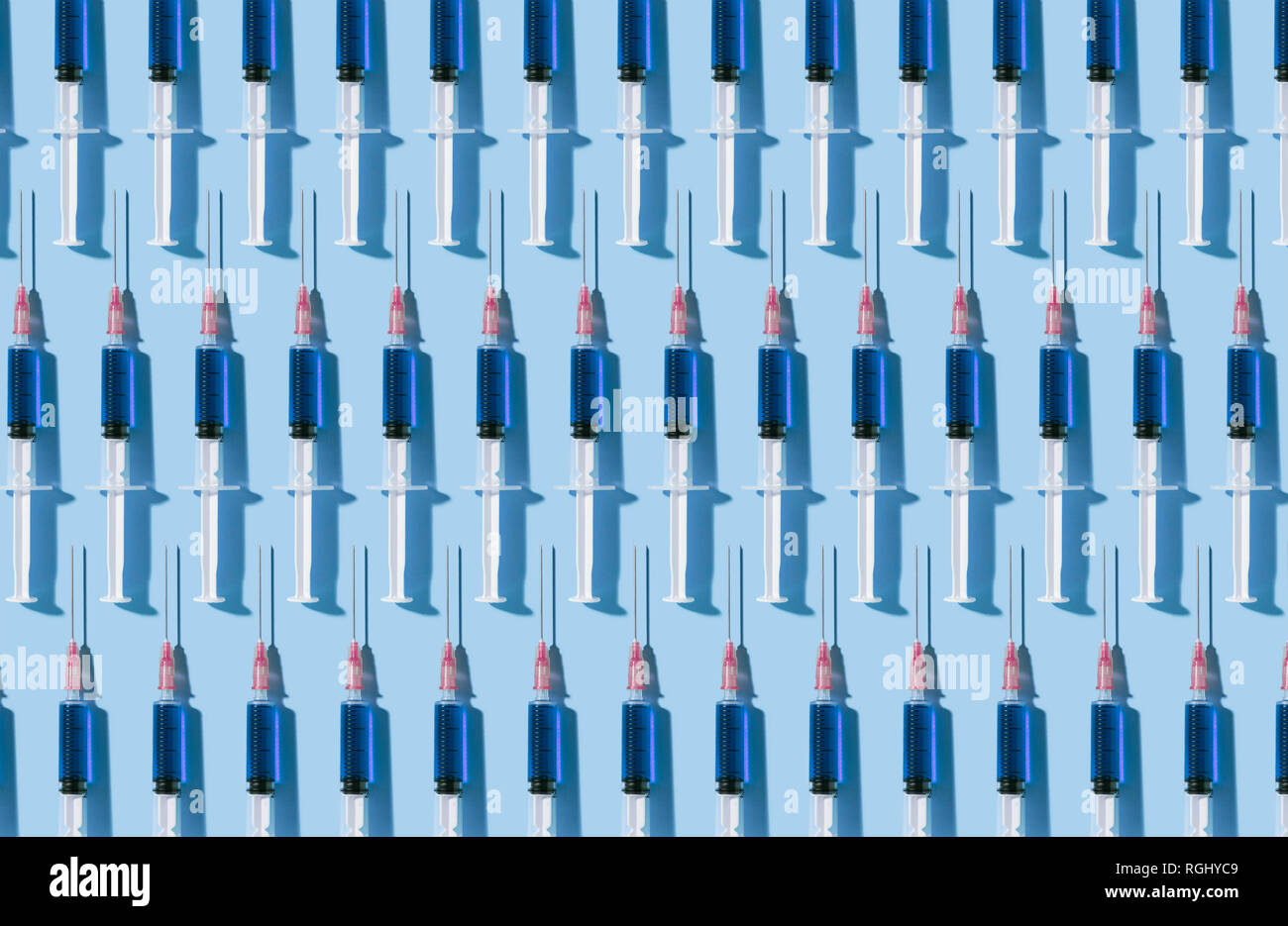 Multiple syringes organized in a pattern over blue background Stock Photo