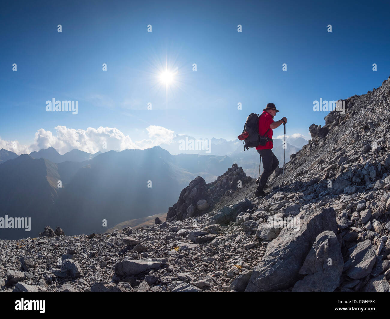 Border region Italy Switzerland, senior man hiking in mountain landscape at Piz Umbrail Stock Photo