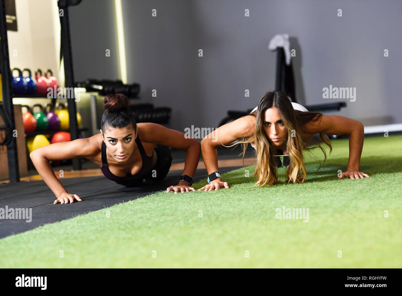 Young women doing push-ups in a gym Stock Photo