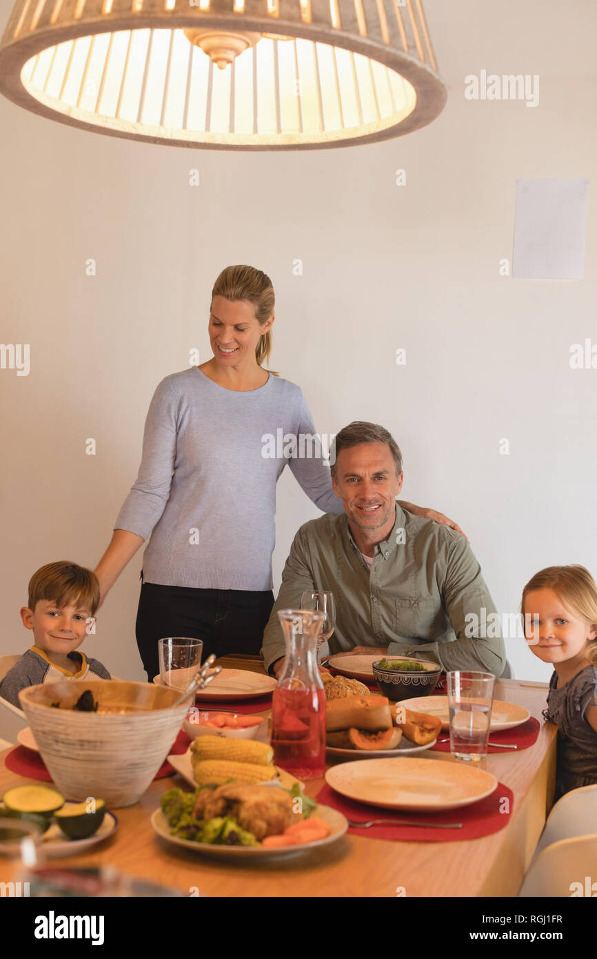 Family sitting on dining table at home Stock Photo Alamy