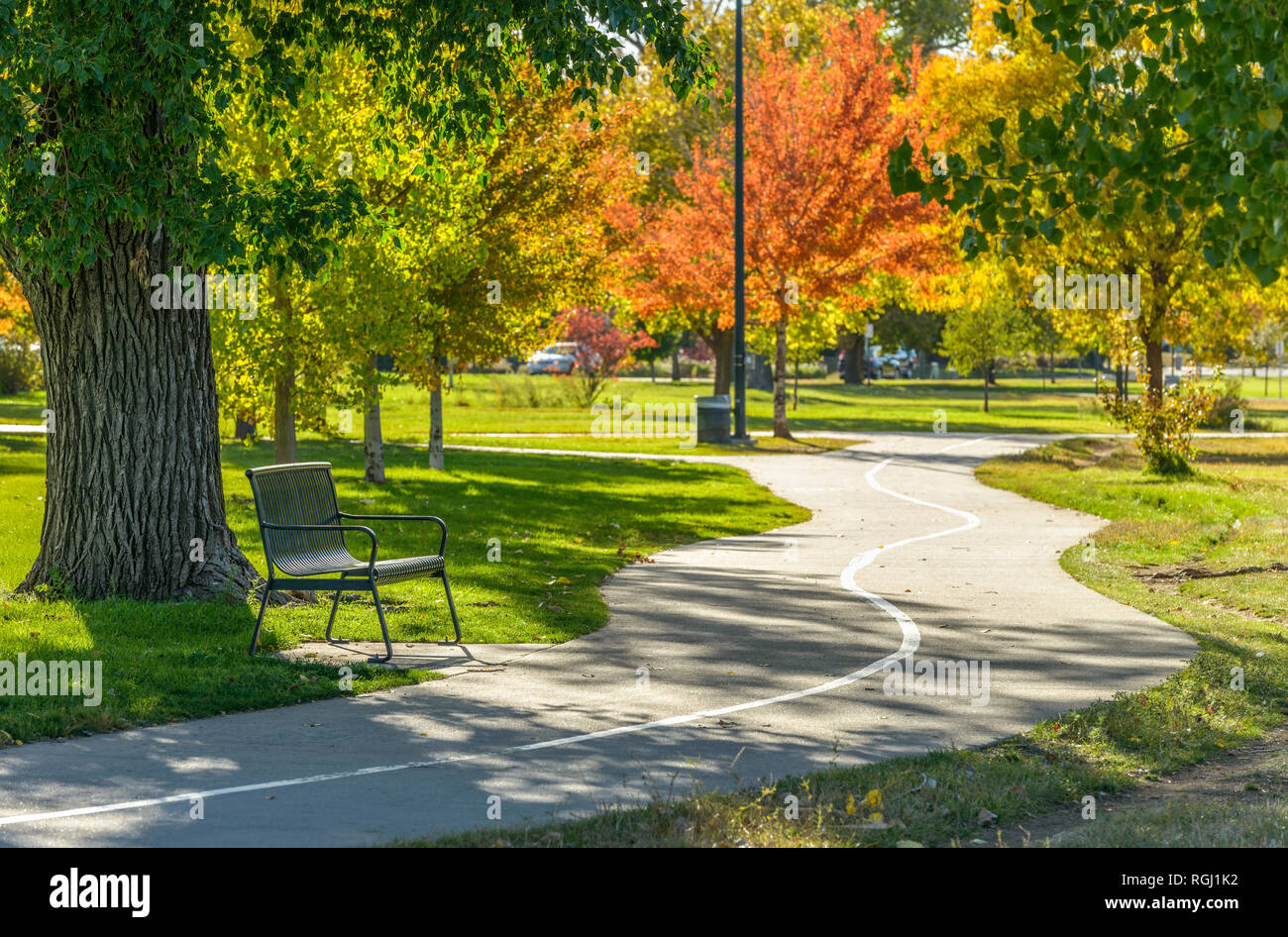 Autumn City Park - A sunny autumn afternoon view of a quiet running trail winding in a city park, Denver-Lakewood, Colorado, USA. Stock Photo