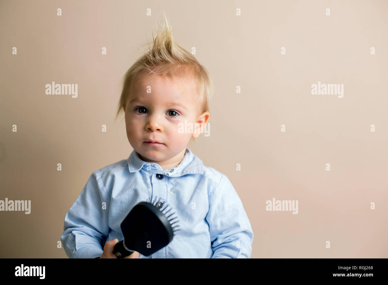 Portrait Of Cute Baby Toddler Boy Holding Hairbrush Having