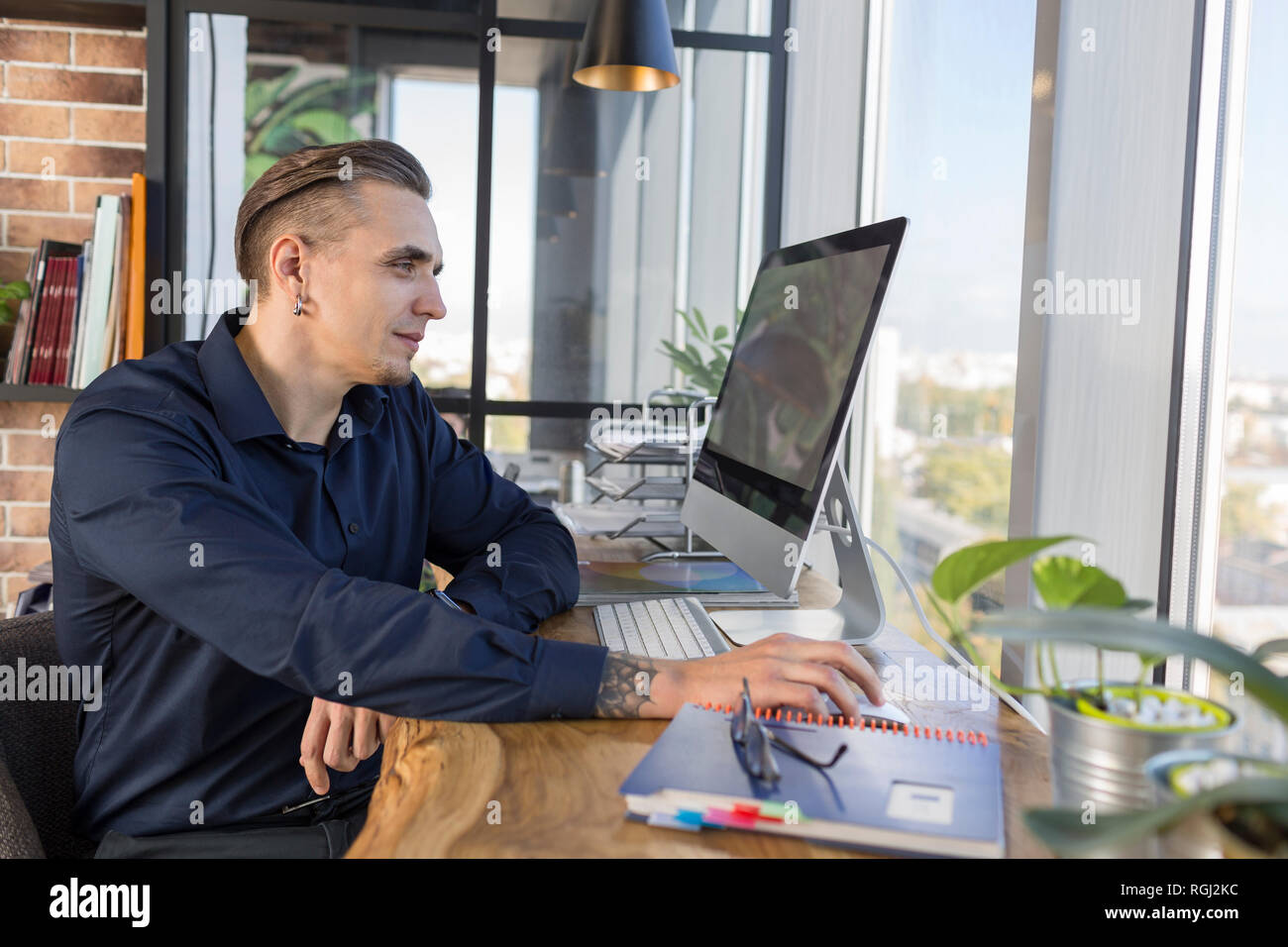 Smiling man working on computer at desk in office Stock Photo