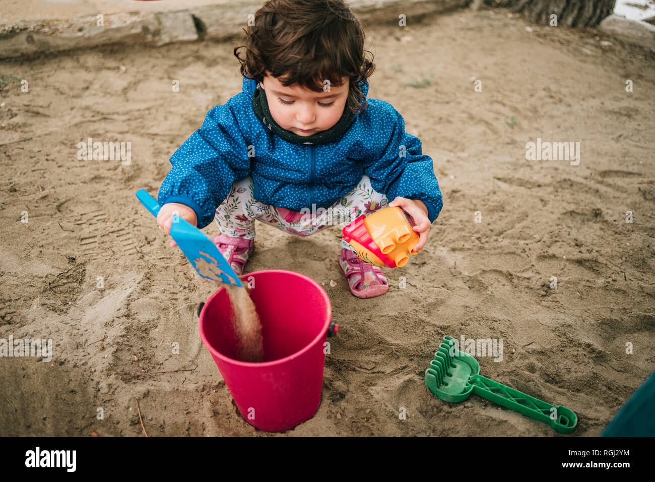 Baby girl playing with sand, shovel and bucket Stock Photo