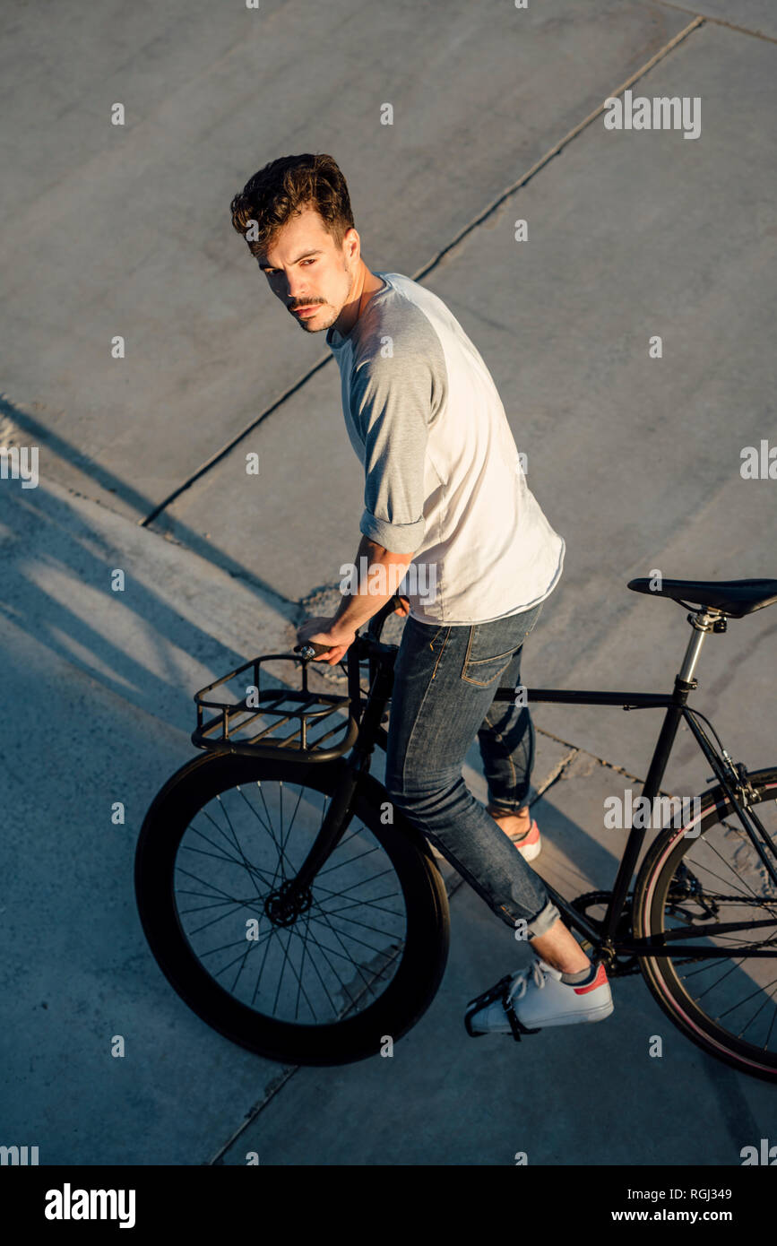 Young man with commuter fixie bike on concrete slabs Stock Photo