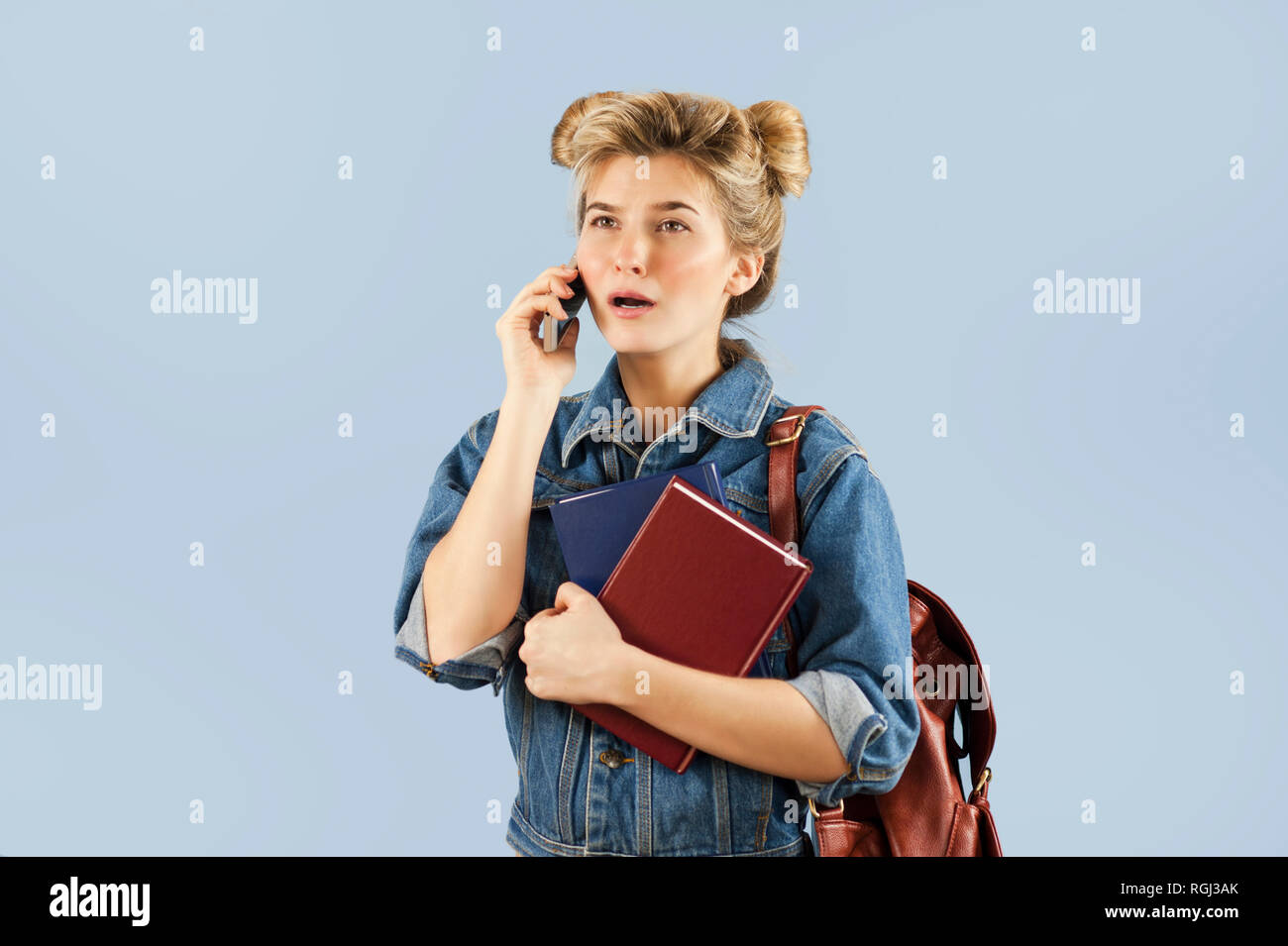 Happy beautiful student girl in a denim jacket with a backpack on her ...
