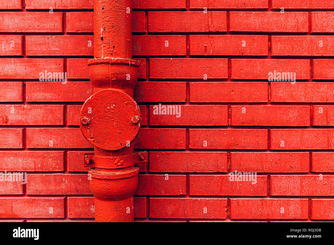 Gutter downpipe and brick wall as urban background Stock Photo