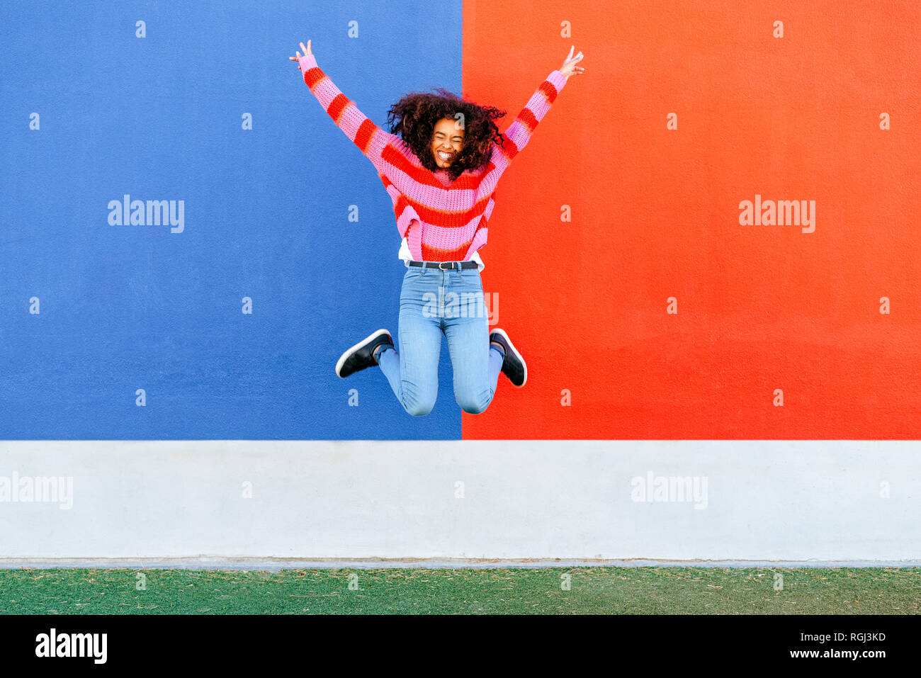 Happy young woman jumping in the air Stock Photo