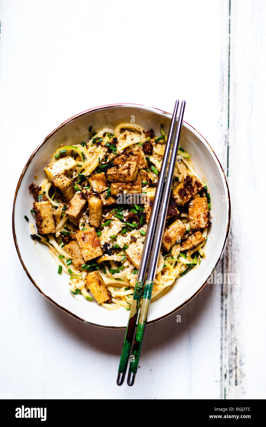 Vegan sesame peanut stir fry with zoodles and tofu Stock Photo