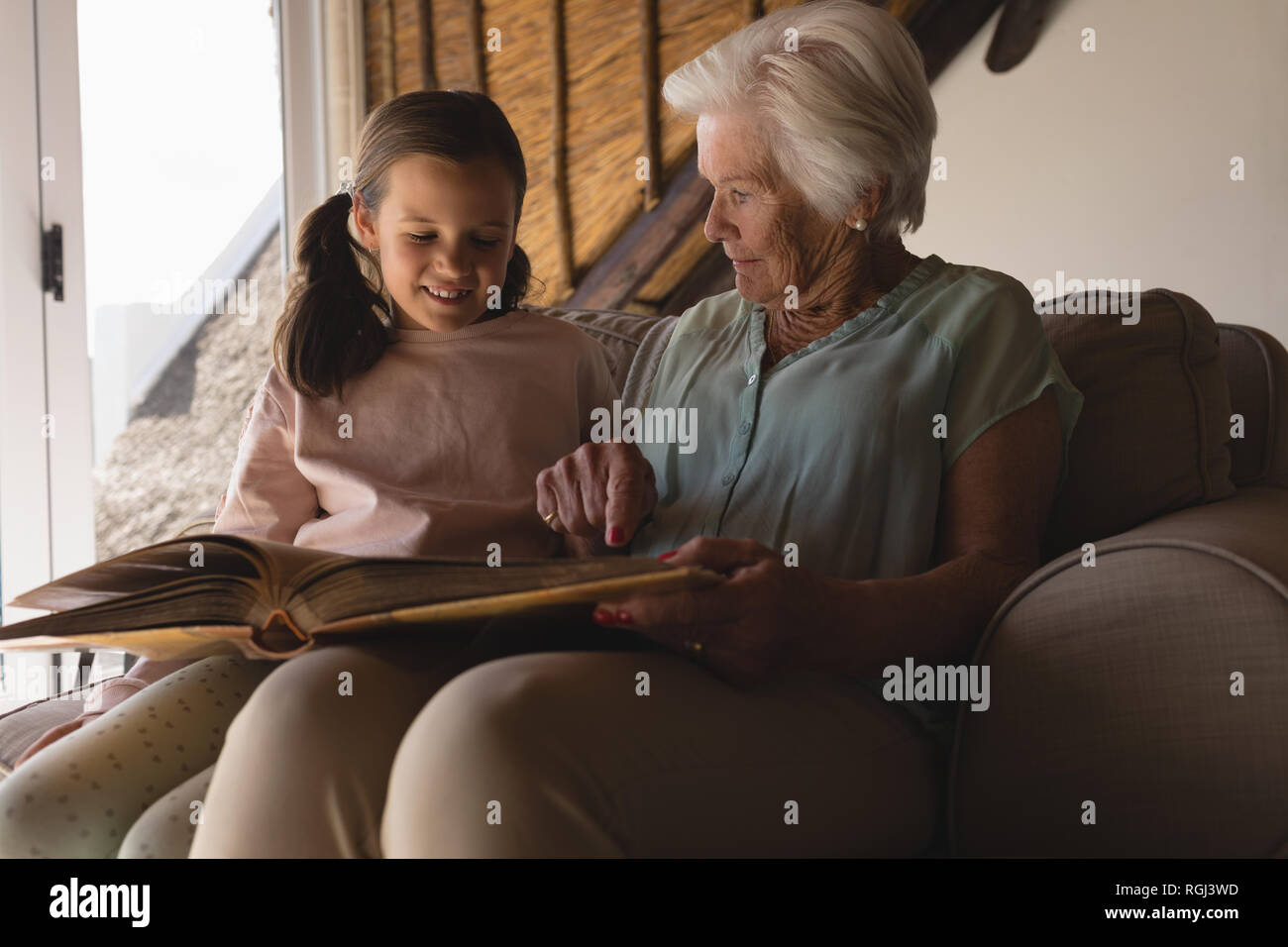 Grandmother and granddaughter looking at photo album Stock Photo. 