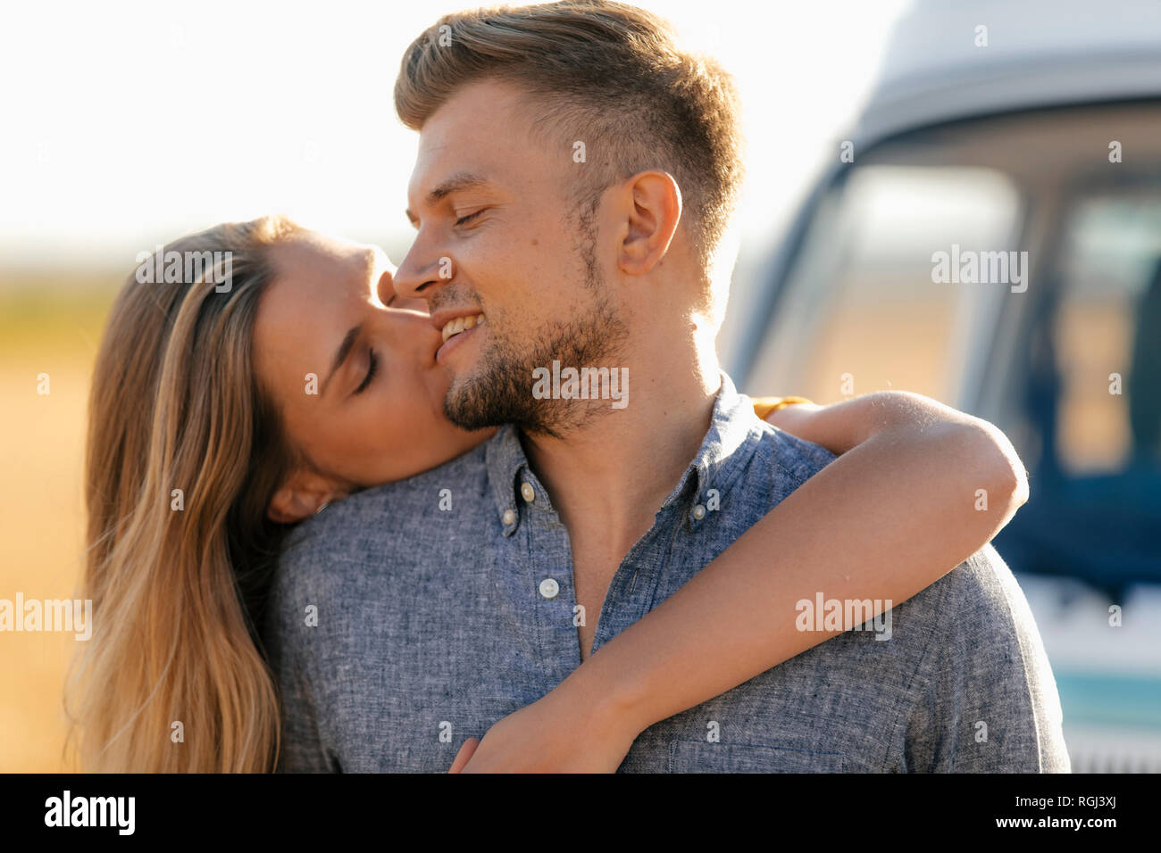 Happy affectionate young couple at camper van Stock Photo