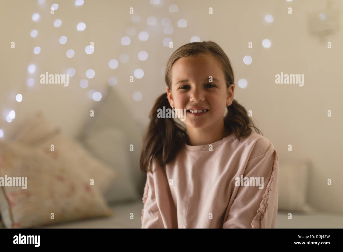 Innocent girl sitting in bedroom at home Stock Photo