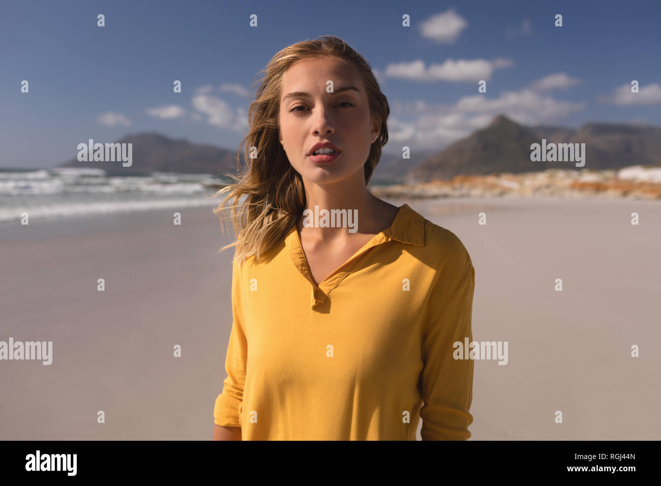 Young woman standing on the beach Stock Photo - Alamy