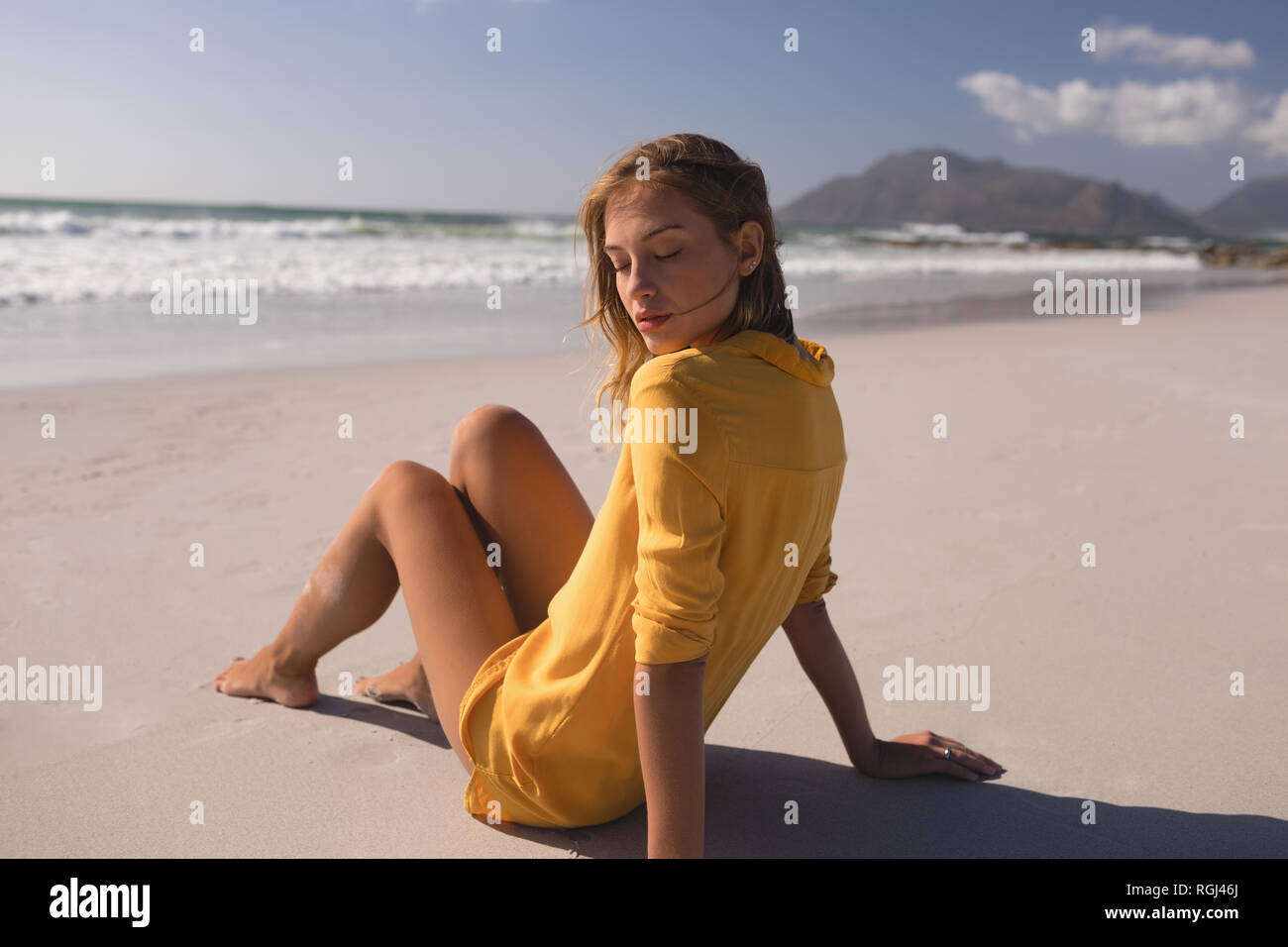 Young woman relaxing at beach on a sunny day Stock Photo
