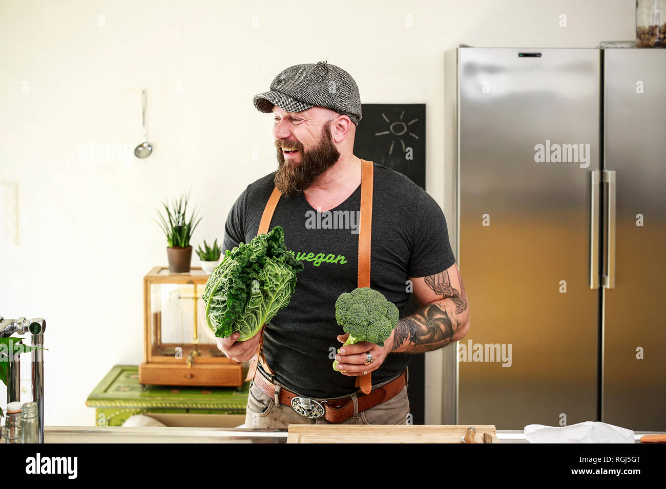 Vegan man choosing vegetables in his kitchen Stock Photo