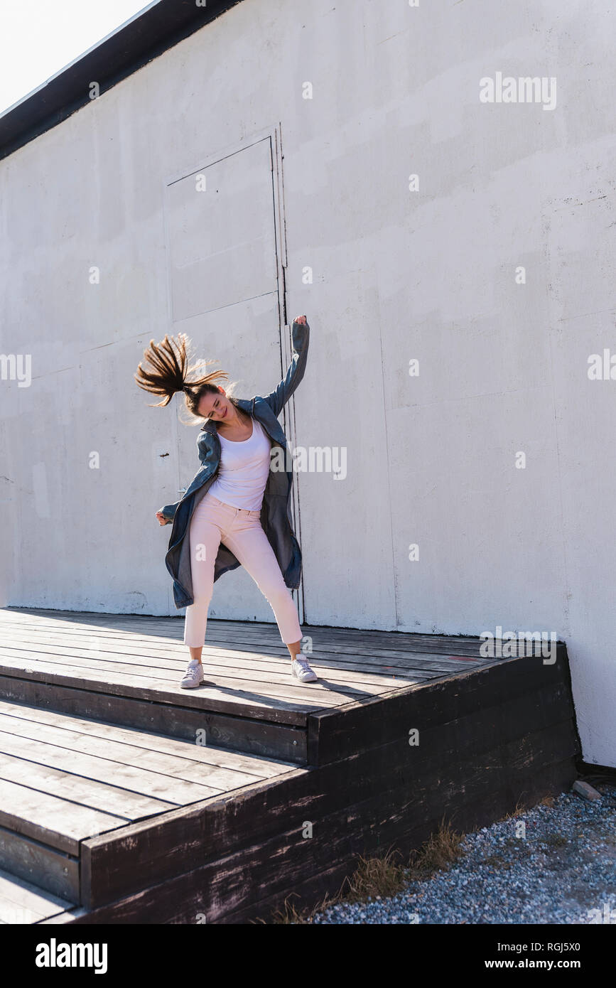Happy young woman moving in front of a wall Stock Photo - Alamy
