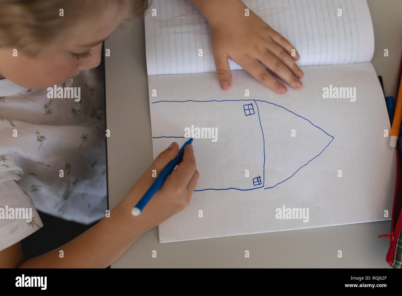 Schoolgirl drawing in classroom sitting at desks in school Stock Photo ...