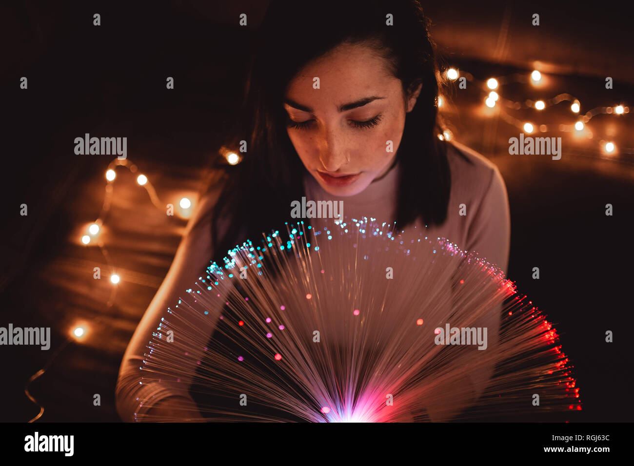 Young Woman with fairy lights in darkness Stock Photo Alamy