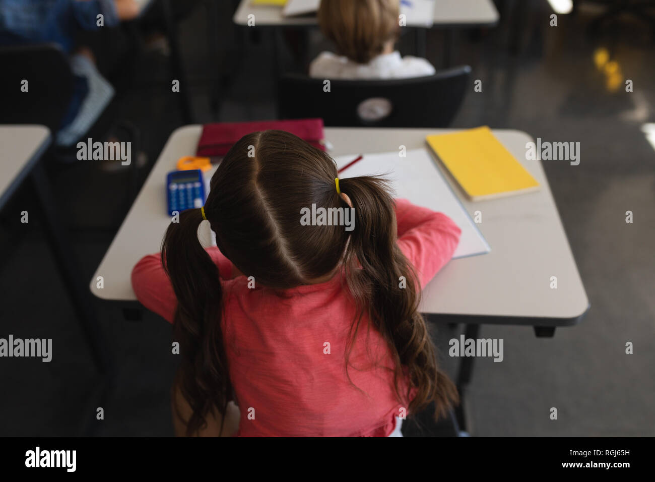 Schoolgirl studying in classroom sitting at desks in school Stock Photo ...