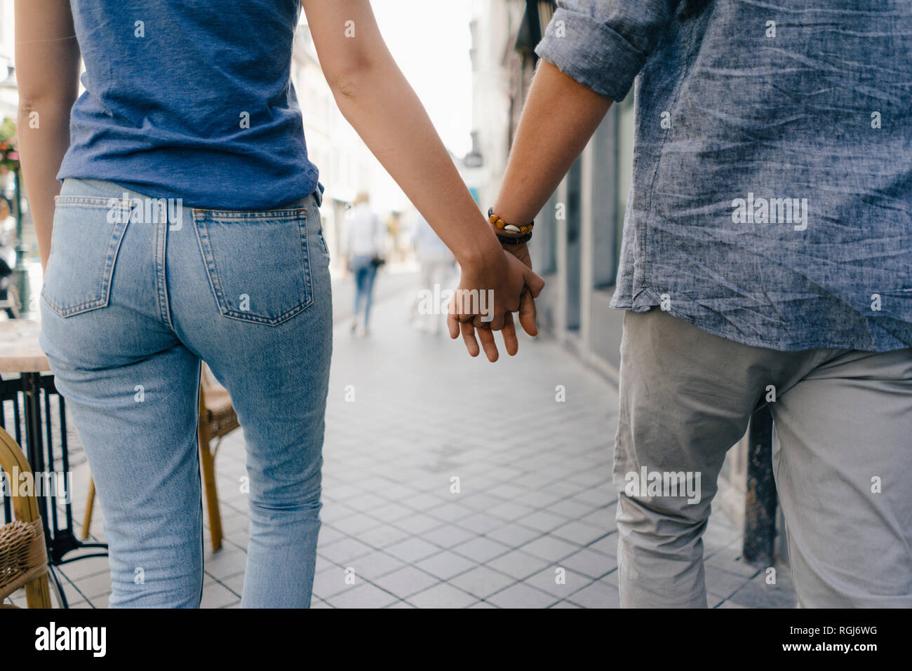 Netherlands, Maastricht, close-up of young couple walking hand in hand in the city Stock Photo