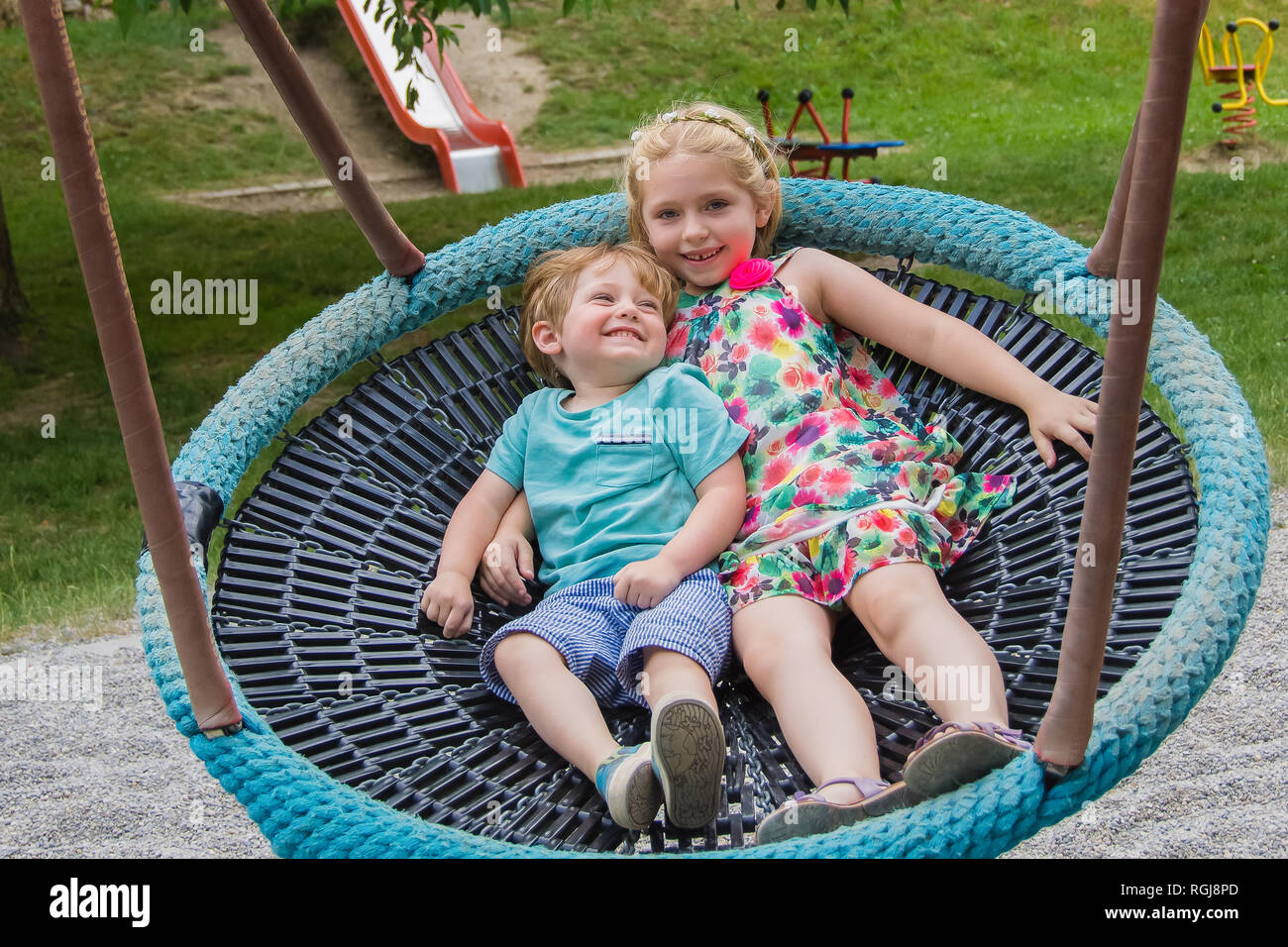 brother and sister on giant swing in playground Stock Photo - Alamy