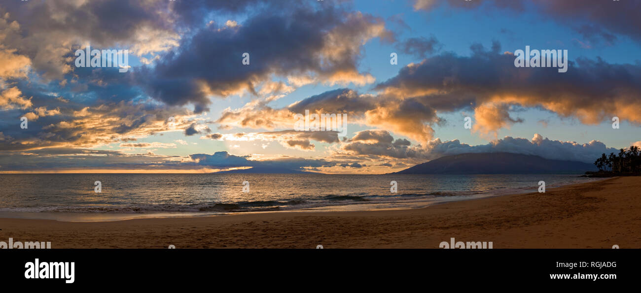 Waves rolling onto a beach under dramatic cloud during sunset Stock ...