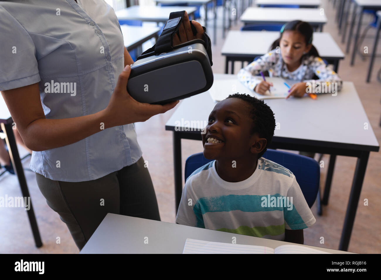 Mid section of female teacher wearing virtual reality headset to