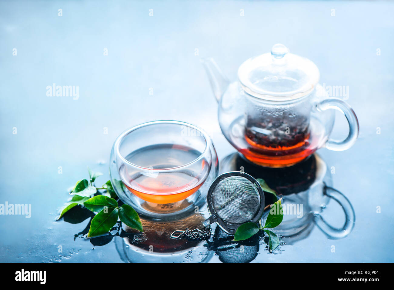 teapot and double wall glass with tea leaves clear and fresh image on a light blue background hot drinks with copy space RGJP04