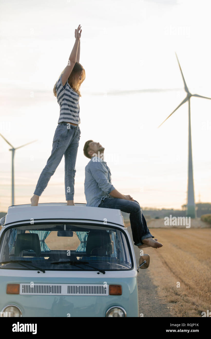 Happy couple on roof of a camper van in rural landscape Stock Photo - Alamy
