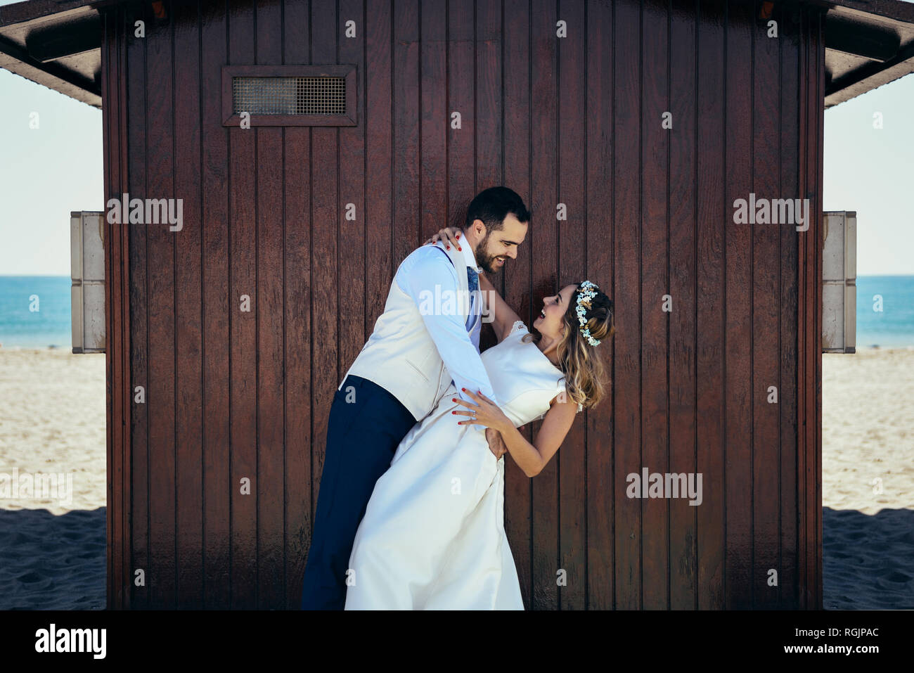 Bridal couple enjoying romantic moments in front of a beach hut Stock Photo