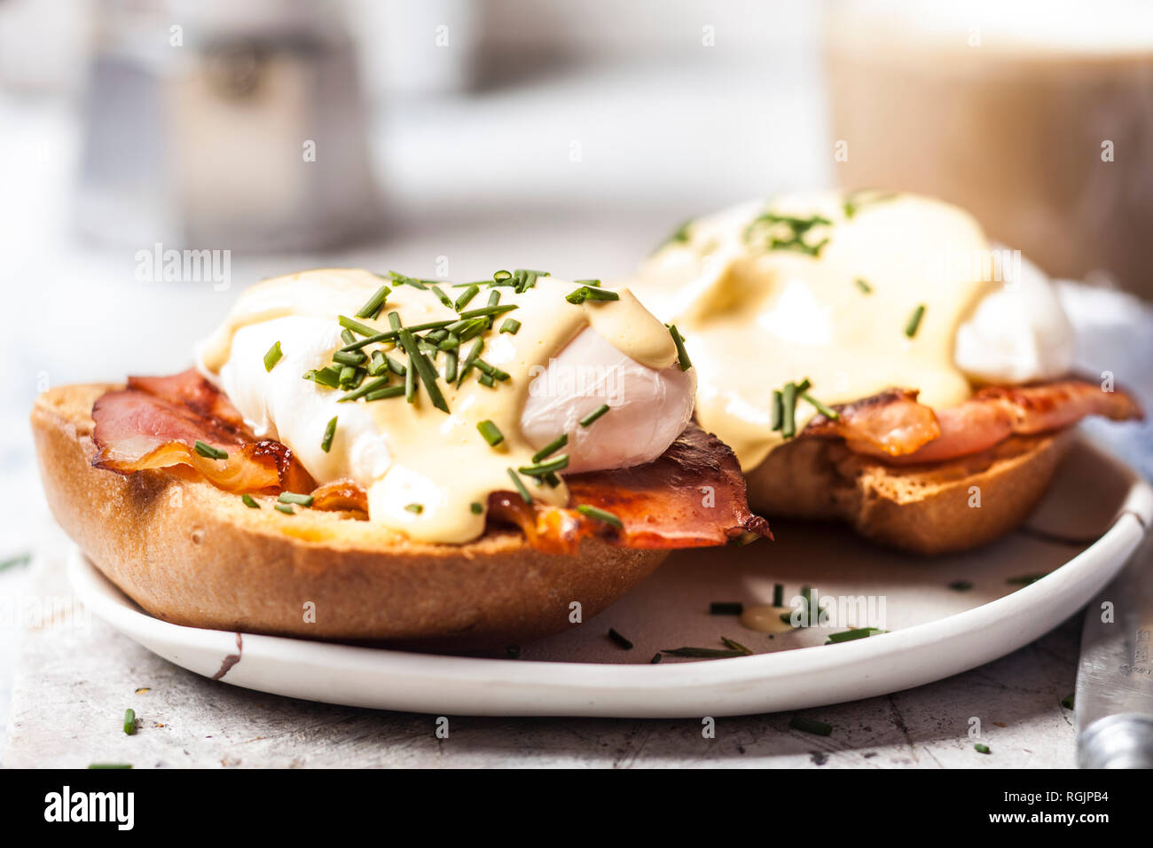 Traditional egg benedict with slices of bacon on toast,  poached egg and hollandaise Stock Photo