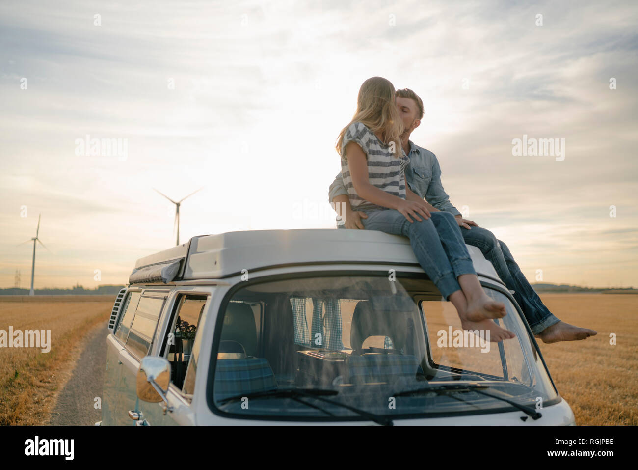 Couple kissing on roof of a camper van in rural landscape Stock Photo ...