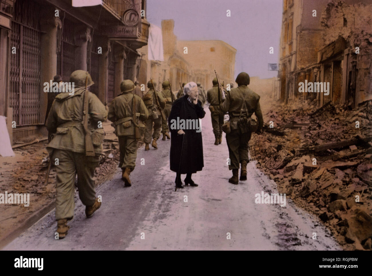 Infantry Troops Marching Through Town, Elderly Woman Looking at Demolished Buildings in German Town, Central Europe Campaign, Western Allied Invasion of Germany, 1945 Stock Photo