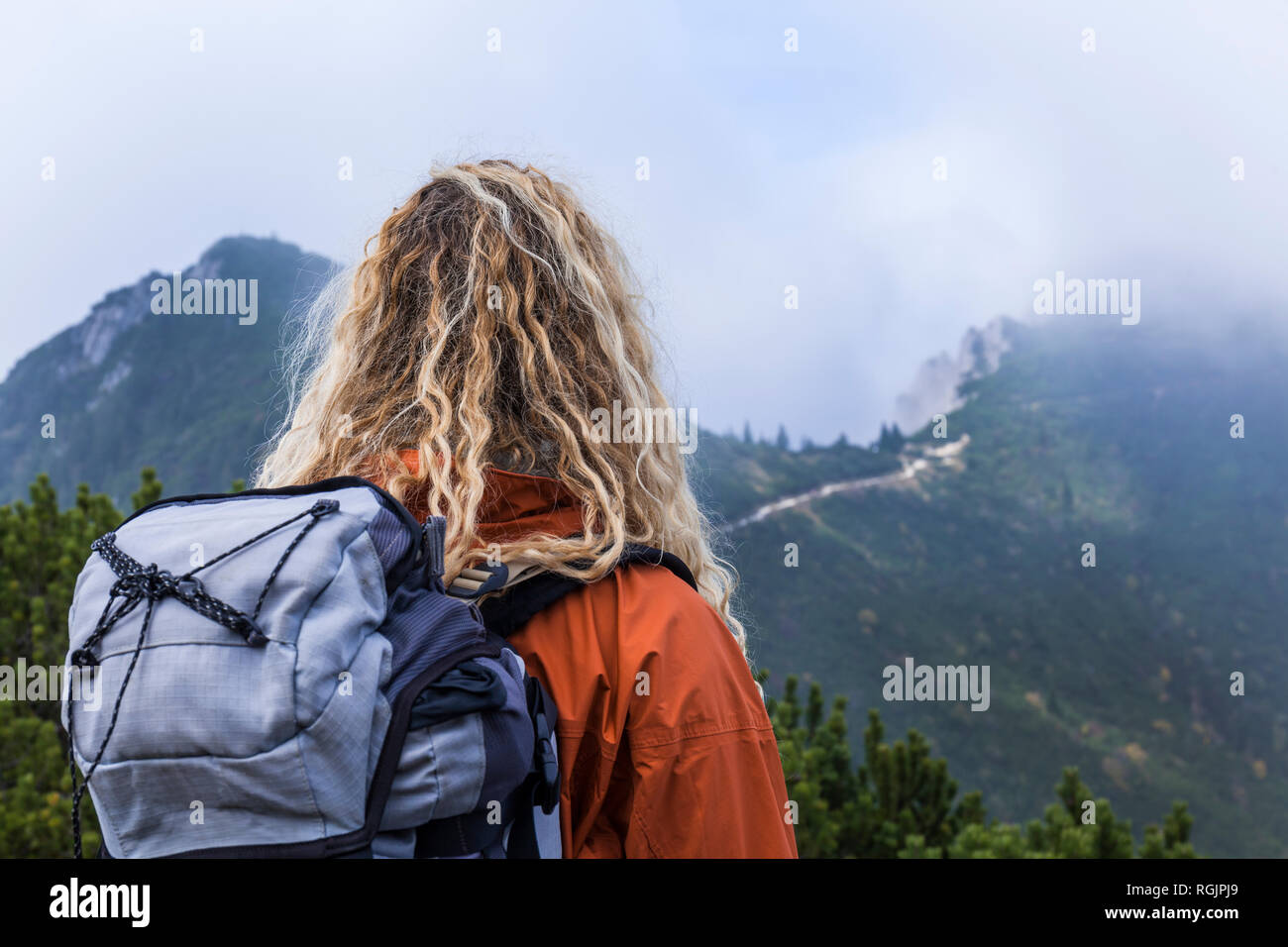 Young woman hiking in the Bavarian mountains, looking at Lake Walchensee Stock Photo