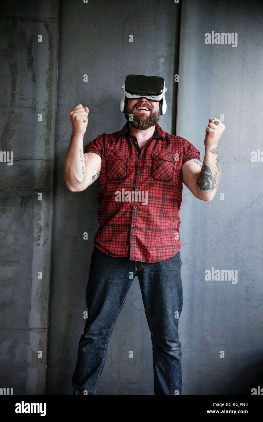 Happy bearded man wearing VR glasses Stock Photo