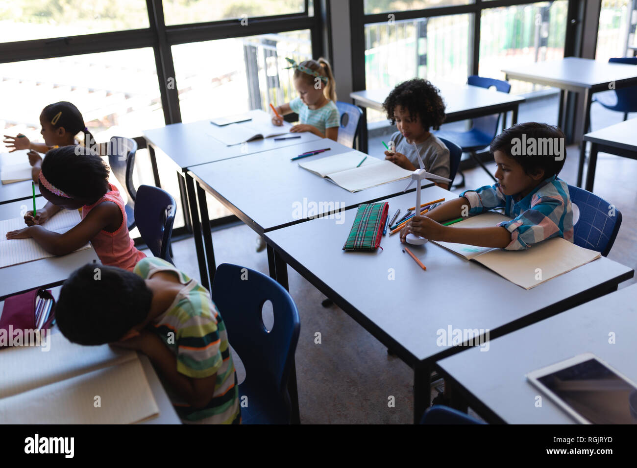High angle view of schoolkids studying at desk in classroom of ...