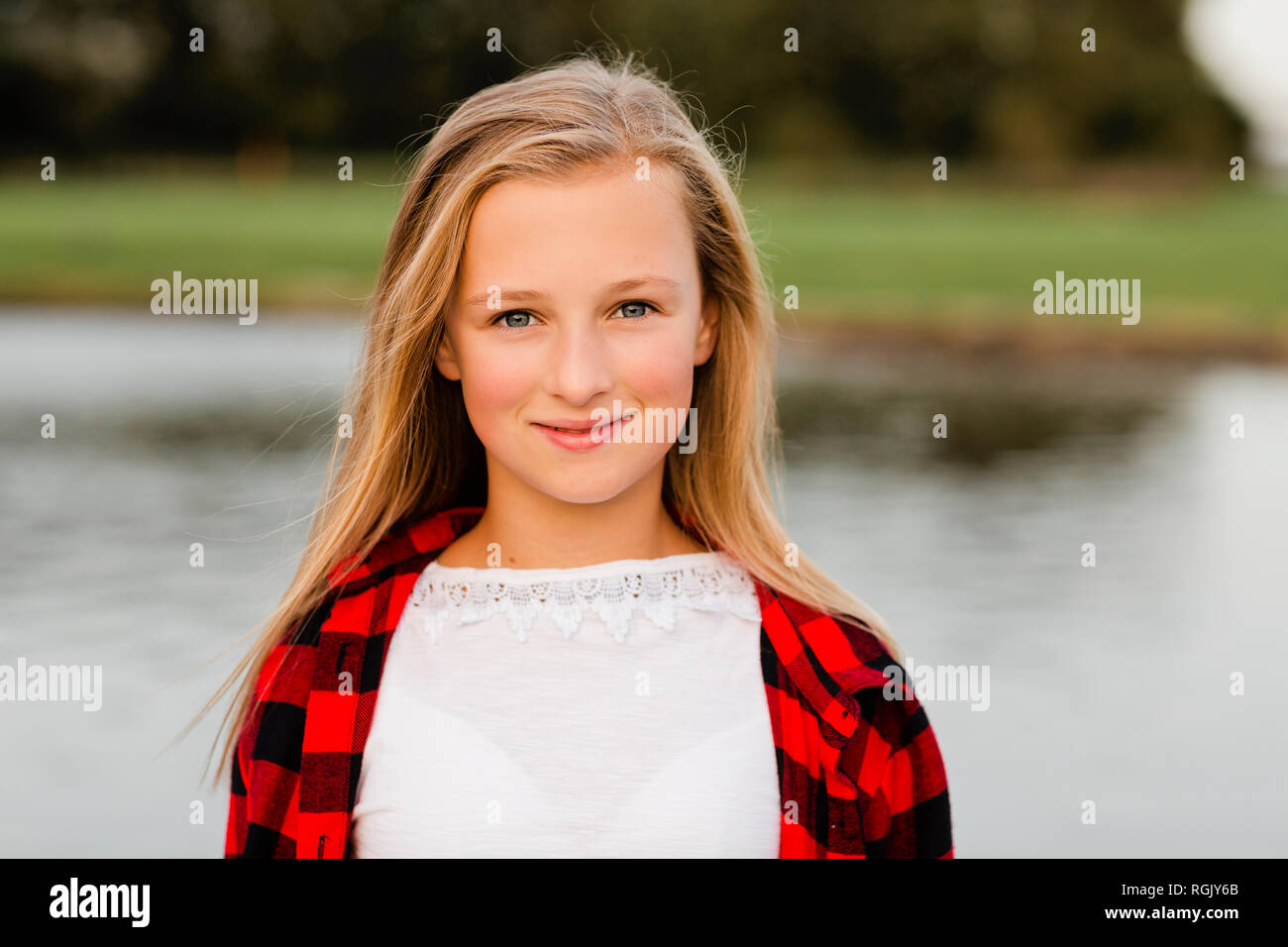 Portrait of smiling blond girl in nature Stock Photo