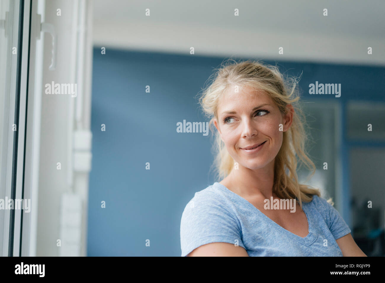 Portrait of smiling blond woman looking sideways Stock Photo