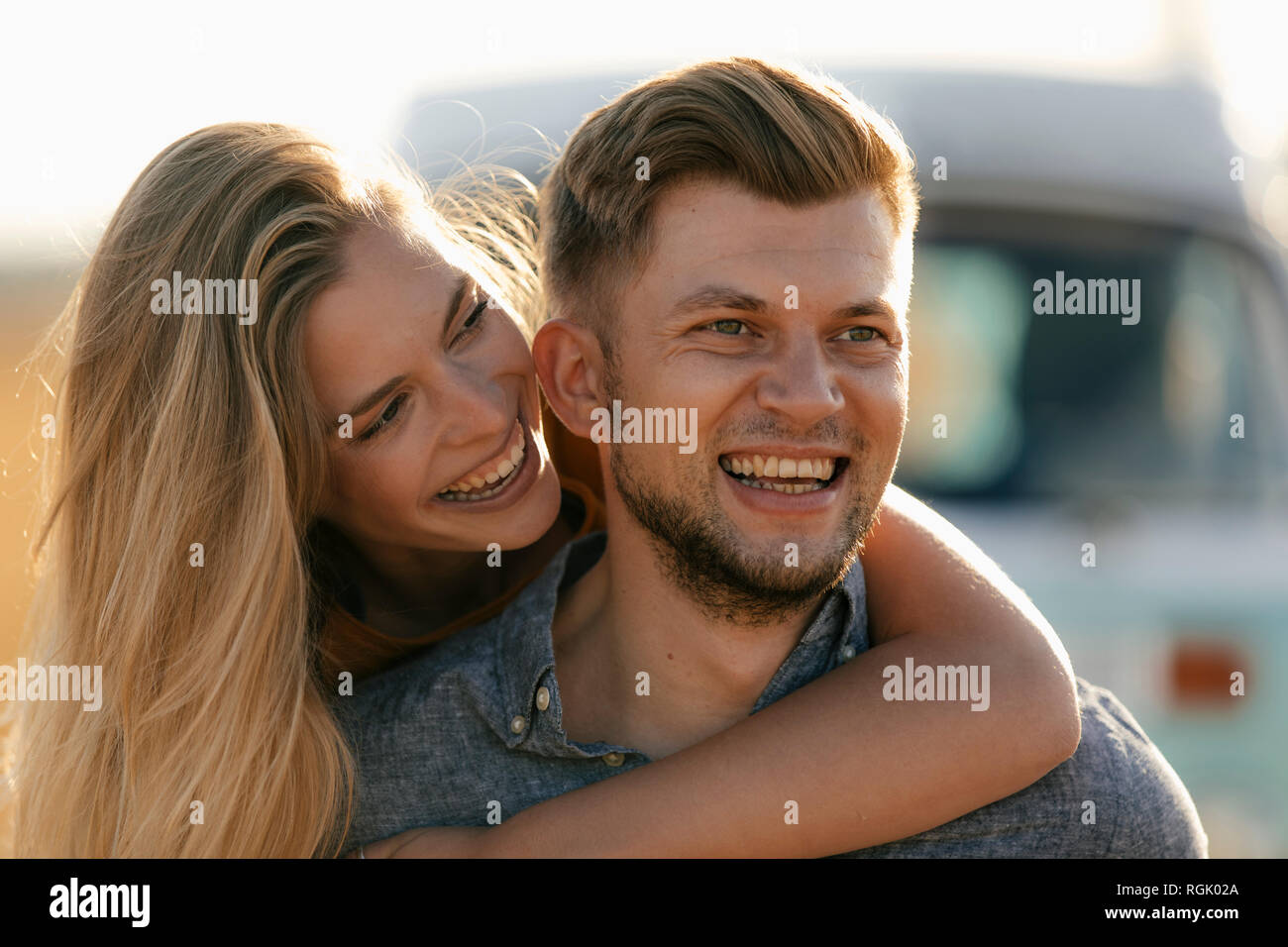 Happy affectionate young couple at camper van Stock Photo