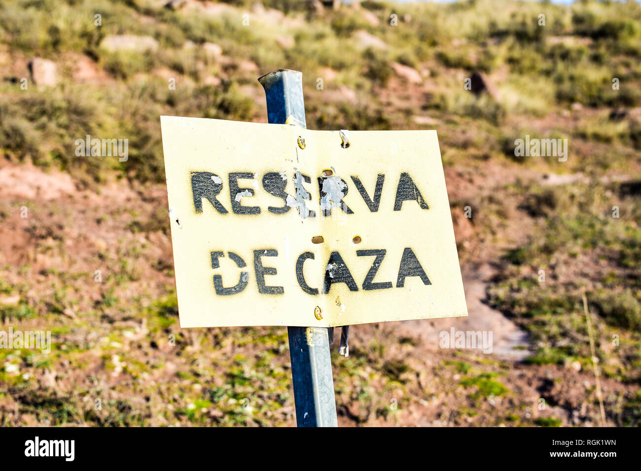 Hunting reserve signal in Spain. Sunny day. Leaky and rusty metal plate. Weathered Stock Photo