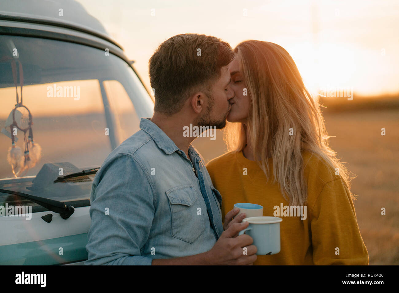 Young couple kissing at camper van in rural landscape Stock Photo - Alamy