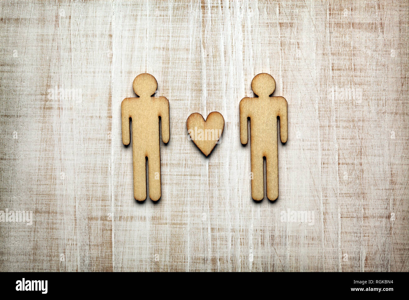 Two men with heart on wooden background Stock Photo