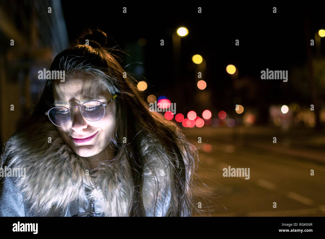 Portrait of a girl with led flashlight. glare of light and dark street. portrait of a beautiful scared model Stock Photo