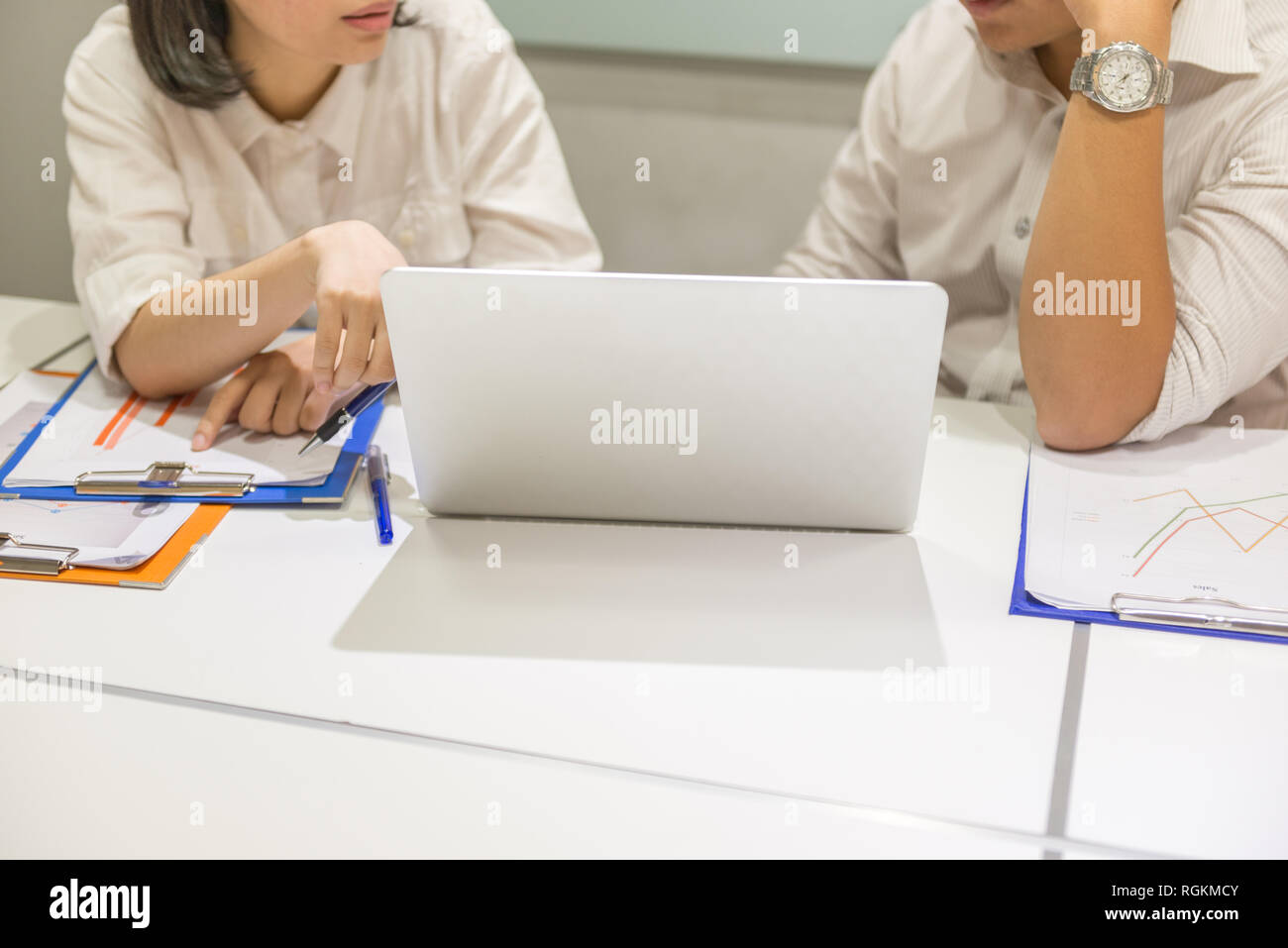 Two business employees discuss about work on laptop Stock Photo