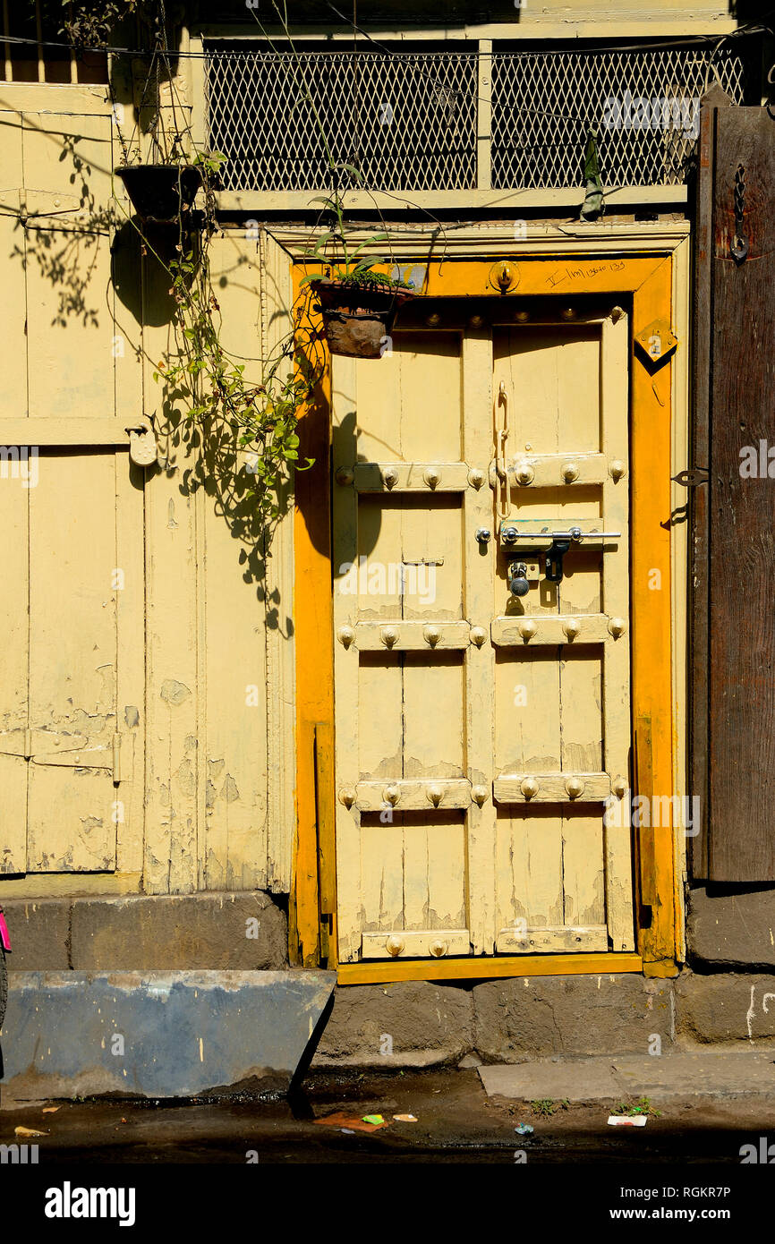 Yellow colored door in Kasba Peth, Pune, Maharashtra, India Stock Photo