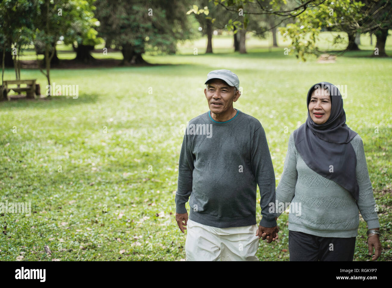 asian senior couple walking in the park and hold hand Stock Photo - Alamy