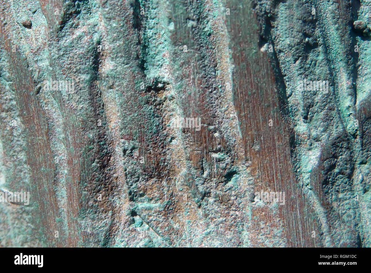 Textural background surface of a copper surface with green oxidized parts Stock Photo
