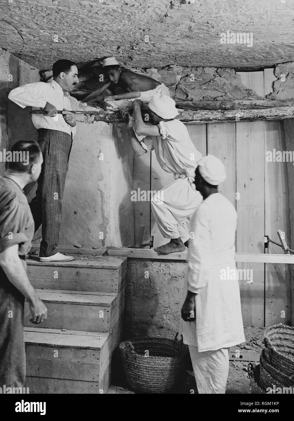 Howard Carter who discovered Tutankhamun's Tomb in the Valley of the Kings, Luxor, Egypt. November 1922. Carter using a pry bar inside the tomb. Scanned from image material in the archives of Press Portrait Service (formerly Press Portrait Bureau) Stock Photo