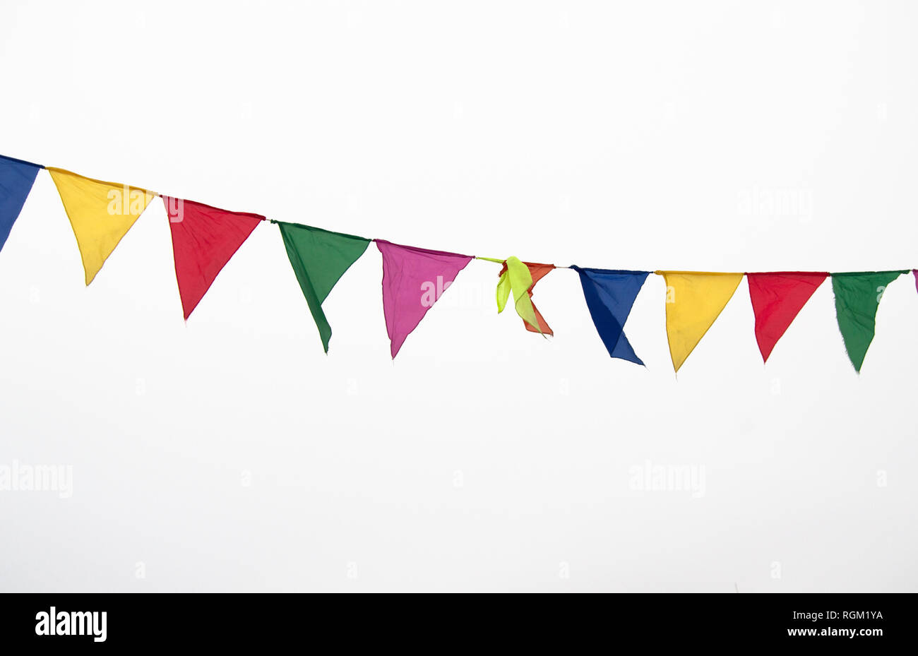 Colorful multicolored triangular flags, isolated on a white background, hang on a rope and flutter in the wind. Holiday decoration, carnival, festival Stock Photo