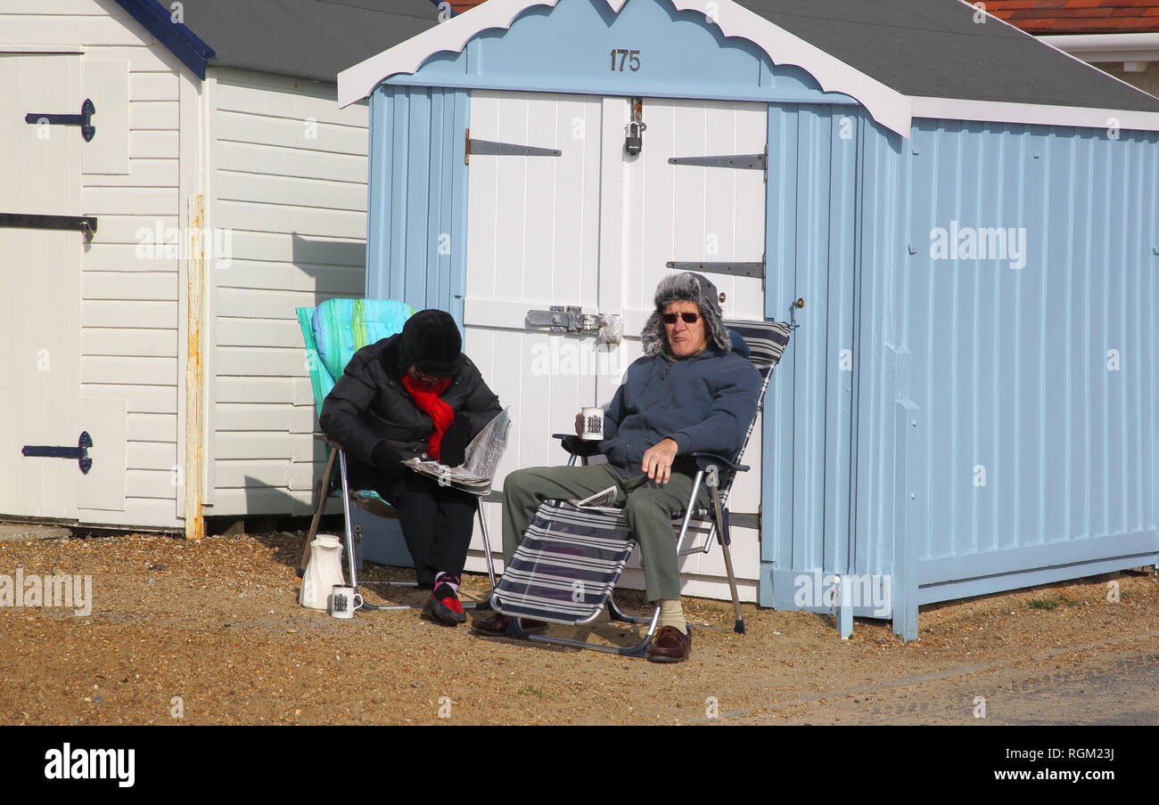 two people outside their beach huts at felixstowe on the suffolk coast in winter Stock Photo